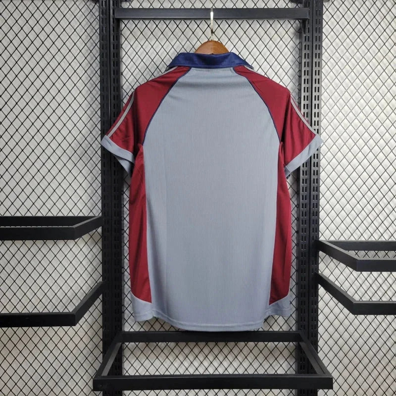 Maillot rétro Bayern Munich 1998/99 Le 12ème Maillot, maillot de football bleu avec logo et détails historiques.