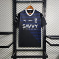 Maillot extérieur de l'équipe Al Hilal 2023/24, modèle Le 12, vue de face avec logo et détails du tissu sportif.