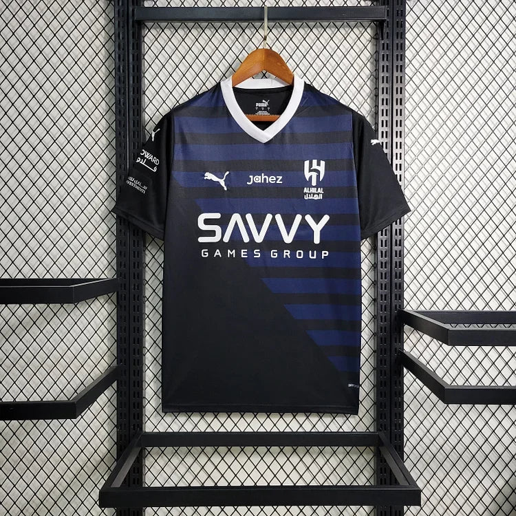 Maillot extérieur de l'équipe Al Hilal 2023/24, modèle Le 12, vue de face avec logo et détails du tissu sportif.