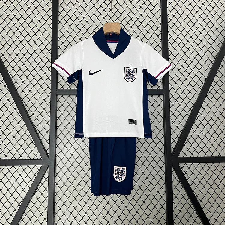 Enfant portant le kit Angleterre Le 12 -ème Maillot, avec maillot blanc et détails rouges et bleus, vue de face.