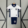 Enfant portant le kit Angleterre Le 12 -ème Maillot, avec maillot blanc et détails rouges et bleus, vue de face.