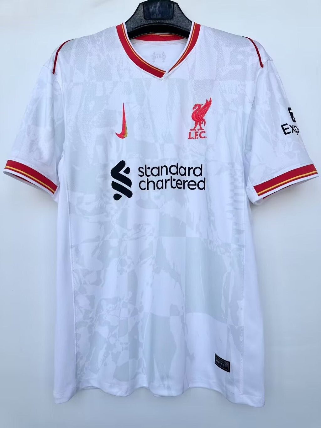 Maillot Liverpool 24/25 blanc, sportif, porté par un mannequin, avec logo et détails du maillot Le 12 -ème Maillot.