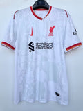 Maillot Liverpool 24/25 blanc, sportif, porté par un mannequin, avec logo et détails du maillot Le 12 -ème Maillot.