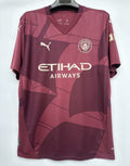 Maillot third Manchester City 2024/2025 de Le 12 -ème Maillot, chemise de football bleue avec logo et détails de l'équipe.