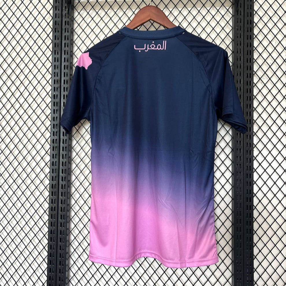 Maillot 25/26 Maroc Le 12 -ème Maillot, rose, jersey de football avec logo et détails colorés, porté sur un mannequin.