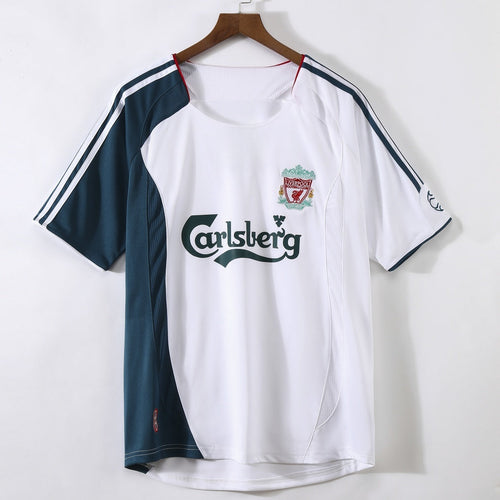 Maillot extérieur rétro Liverpool 2006-2007, marque Le 12, en tissu rouge avec logo et détails blancs.
