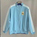 Veste coupe-vent réversible Argentine Le 12 -ème Maillot, design coloré et pratique, portée en plein air.