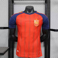 Maillot domicile Espagne 25/26, marque Le 12, vue de face, avec les couleurs rouges et jaunes et logo officiel.