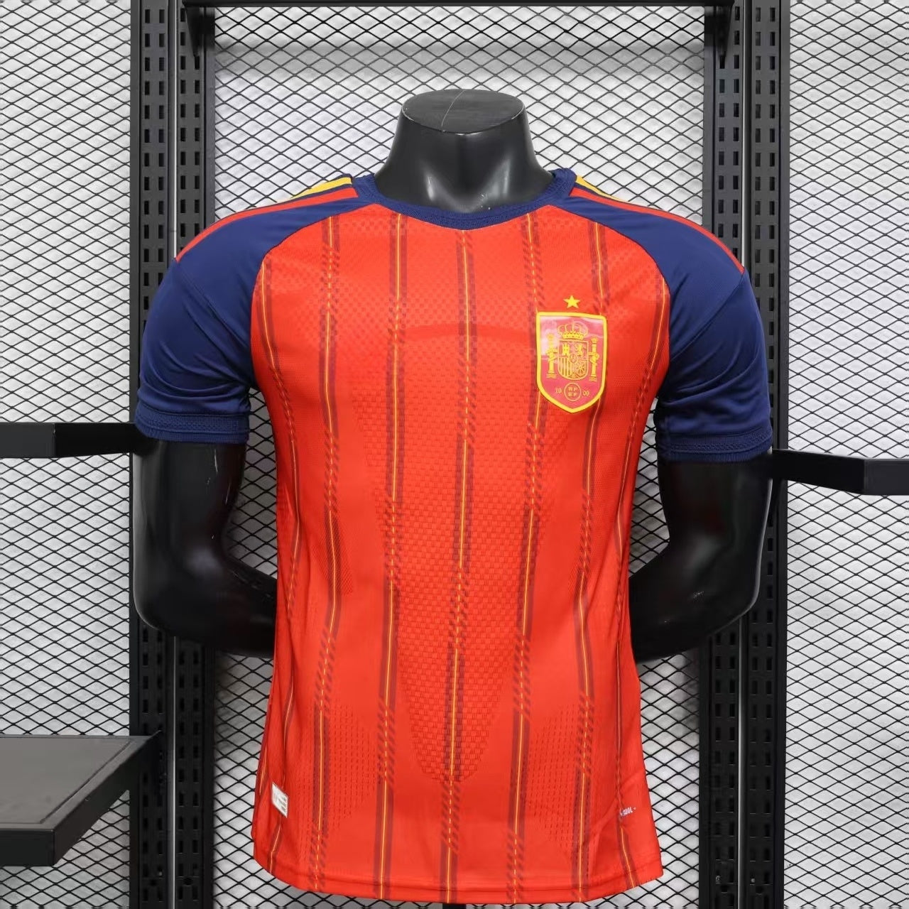 Maillot domicile Espagne 25/26, marque Le 12, vue de face, avec les couleurs rouges et jaunes et logo officiel.