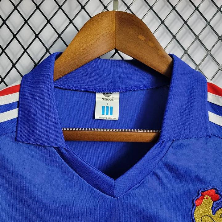 Maillot rétro de l'équipe de France 1985/86, maillot de football blanc avec logo et détails bleu et rouge, de la marque Le 12.