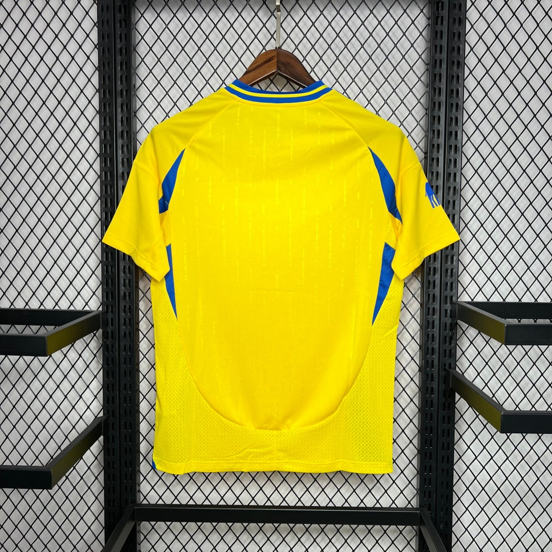 Maillot domicile 24/25 AL-NASSR Le 12-ème, maillot de football rouge avec logo et détails colorés, vue frontale.