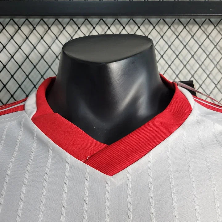 Maillot Manchester United 2023 2024 Le 12 -ème Maillot, vue de face avec logo et design officiel, tissu blanc et détails rouges.