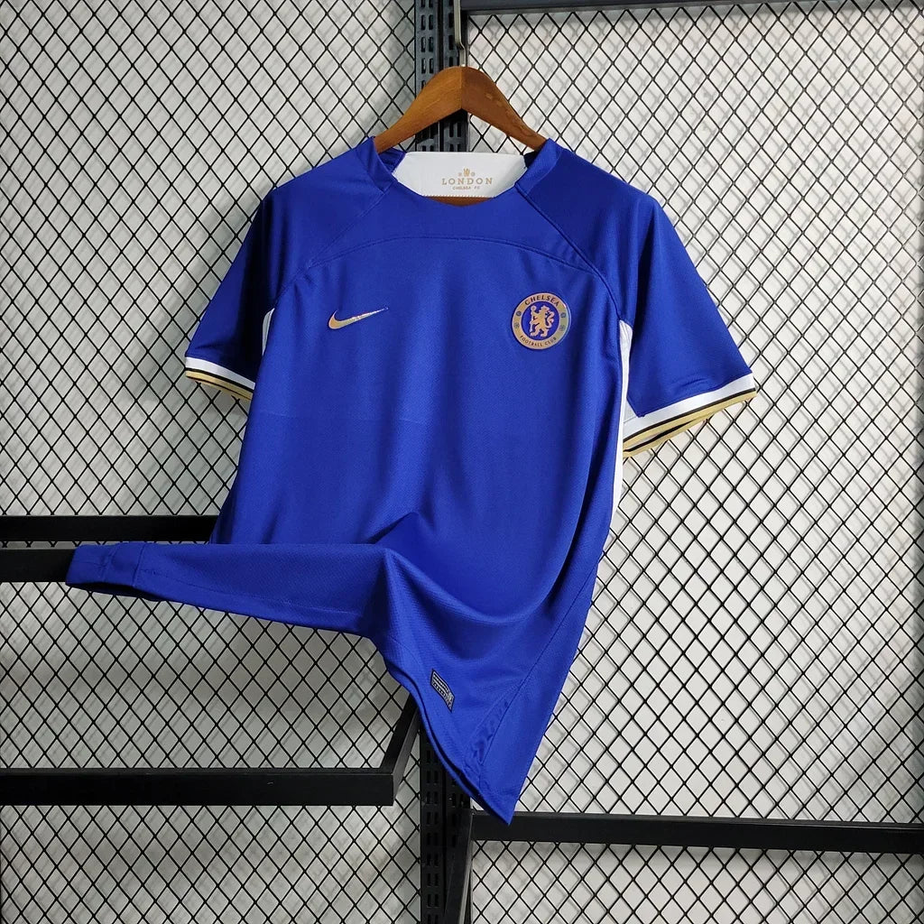 Maillot domicile Chelsea 2023-2024 Le 12 -ème Maillot, maillot de football bleu avec logo et détails de la saison.