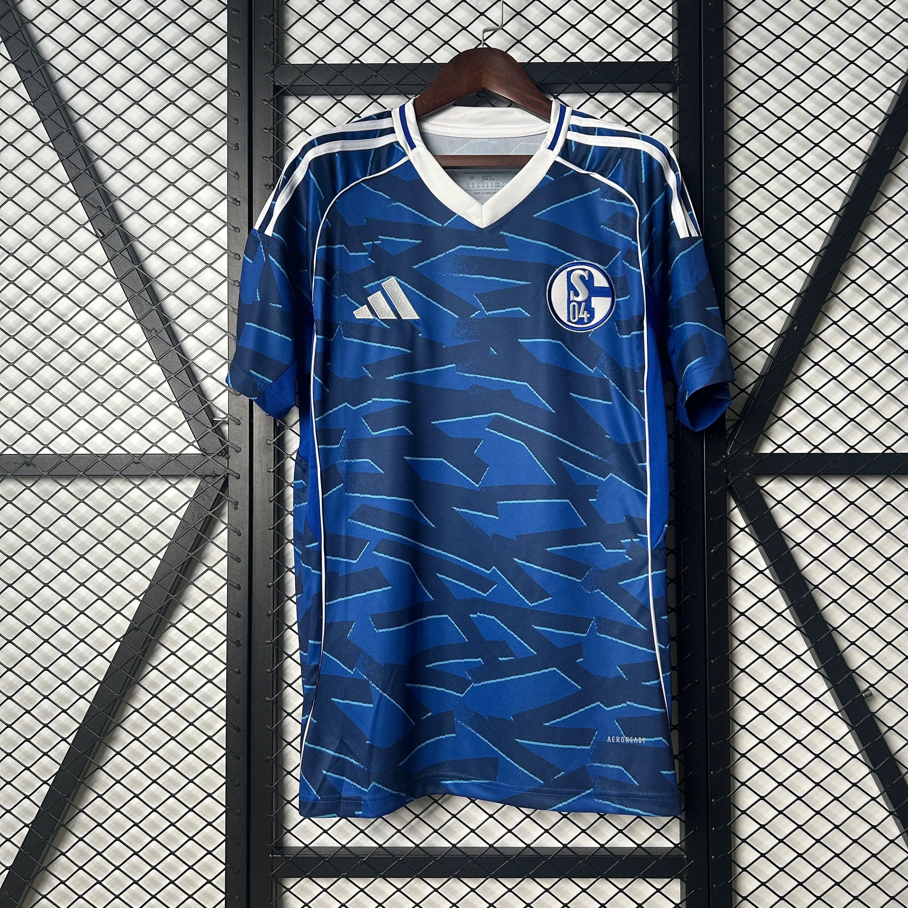 Maillot domicile Schalke 04 25/26 de Le 12, logo de l'équipe et design officiel visible sur le jersey blanc et bleu