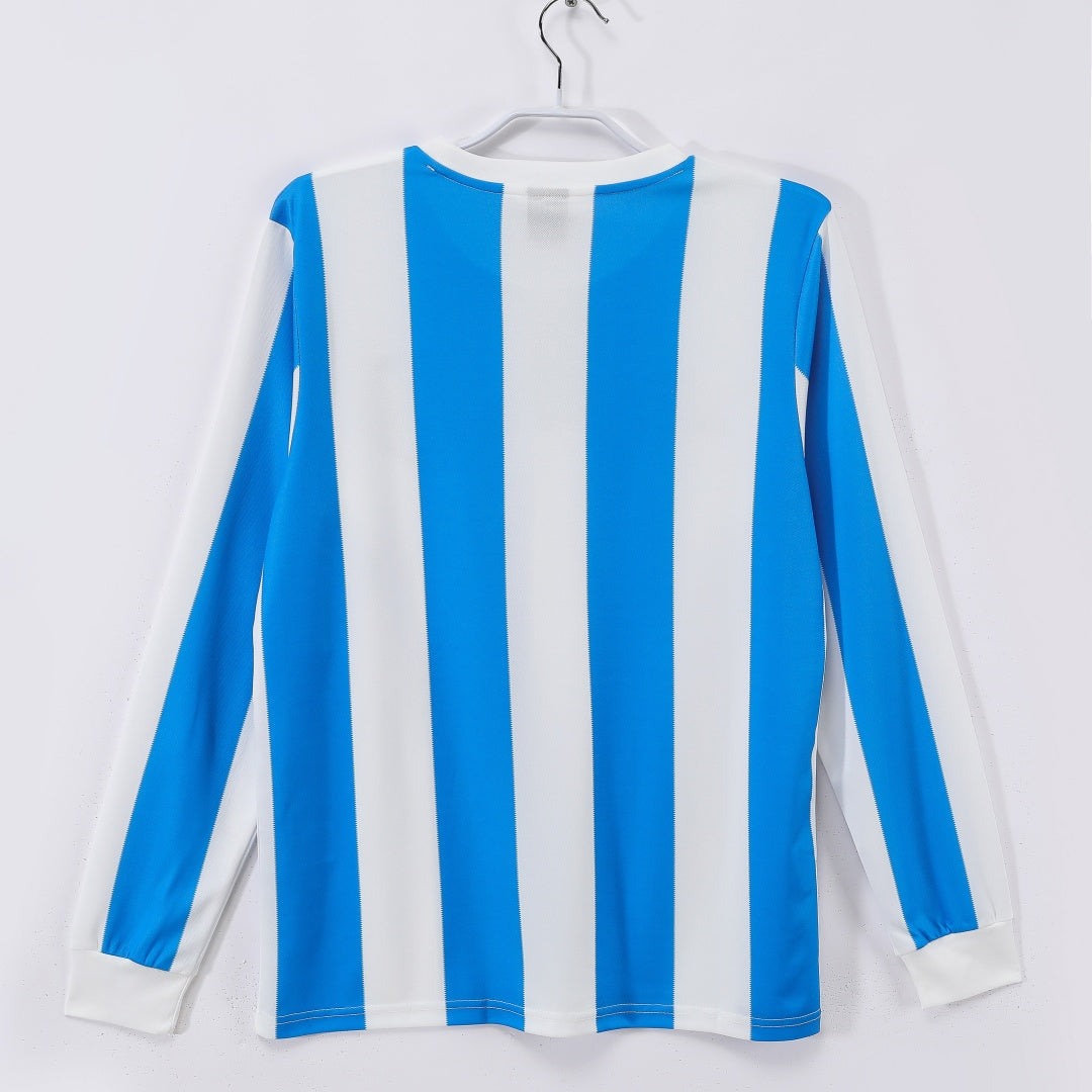 Maillot Argentine domicile rétro 1986 à manches longues, couleur bleu et blanc, marque Le 12 -ème Maillot, vue de face.