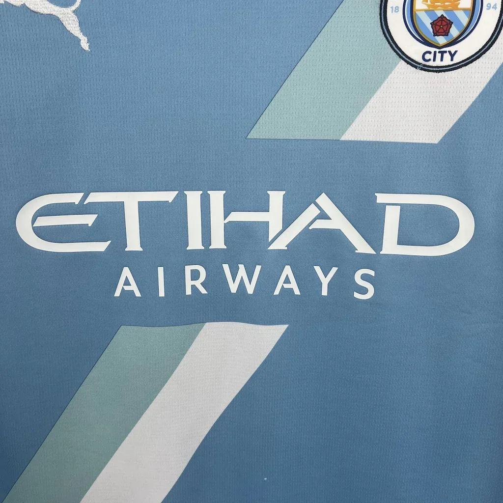 Maillot Manchester City 2025-26 Le 12 -ème Maillot, maillot de football avec logo et détails en bleu et blanc.