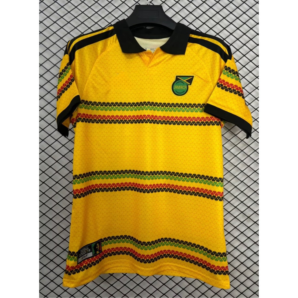 Maillot domicile 25/26 Jamaica Le 12 -ème Maillot, maillot de football jaune avec logo et détails bleus.