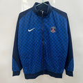 Veste coupe-vent réversible Le 12 -ème Maillot PSG, veste sportive avec logo du Paris Saint-Germain visible sur l'image.