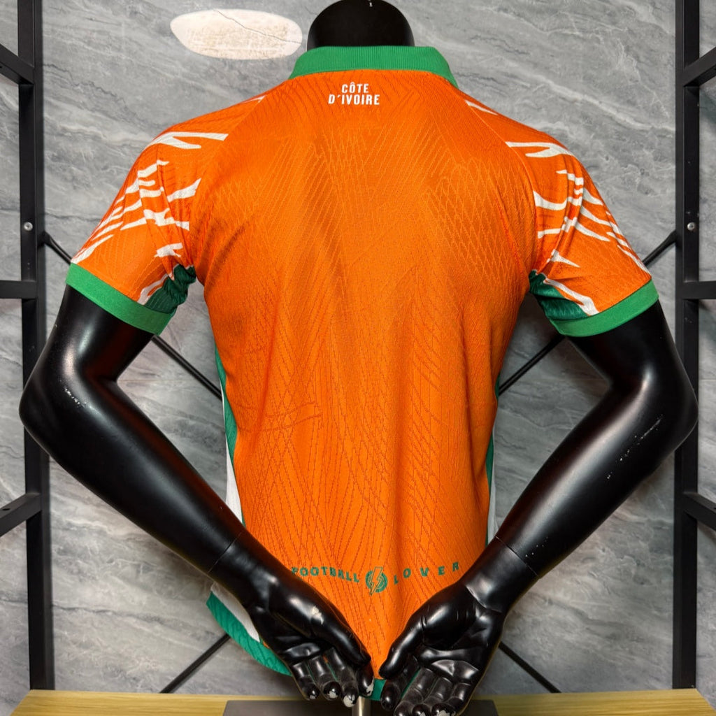Maillot orange de l'équipe Côte d'Ivoire 25/26 ans, modèle Le 12 -ème Maillot, vue de face avec logo et détails sportifs.