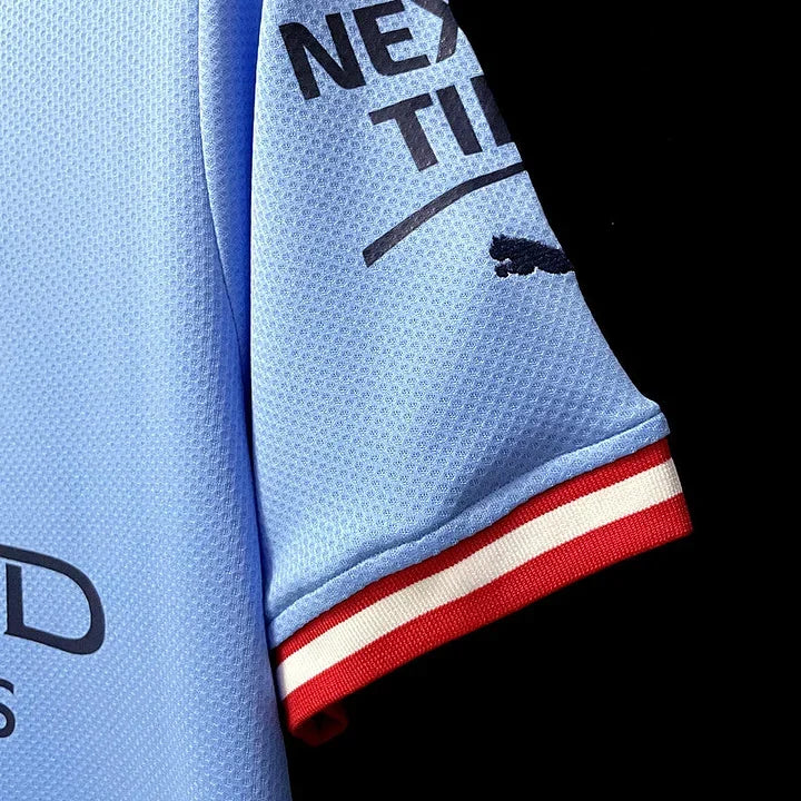 Maillot domicile Manchester City 2022/23 Le 12-ème Maillot, maillot de football bleu avec logo et détails officiels.
