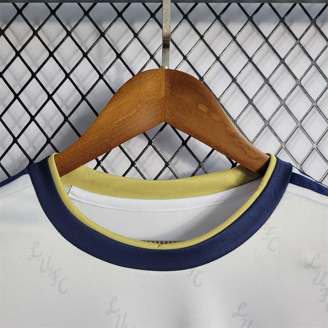 Maillot Leeds United 2022-23 Le 12 -ème Maillot, maillot de football blanc avec logo Leeds United et détails verts.