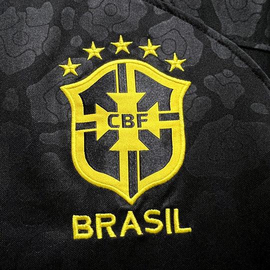 Maillot de football Brésil 2023-2024 anti-racisme, marque Le 12, avec logo et design bleu et jaune, porté par un joueur.