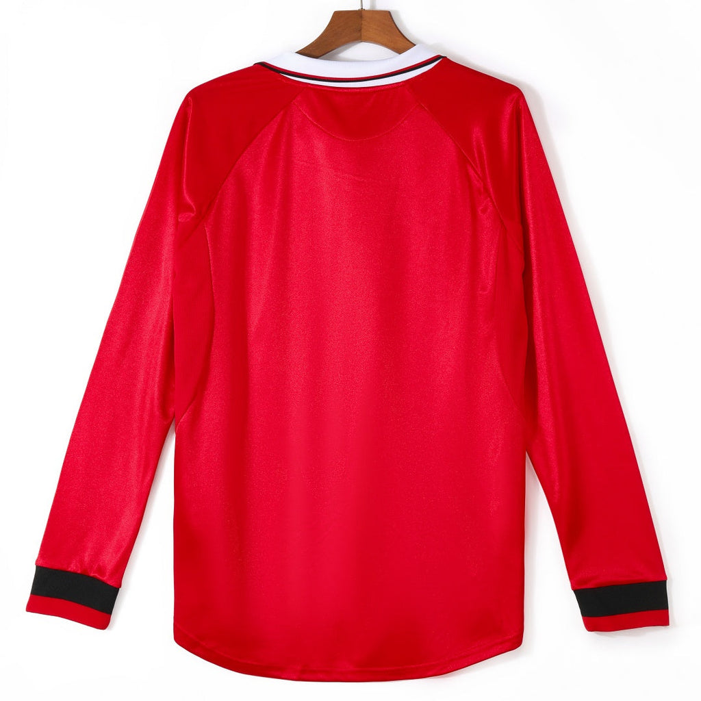 Maillot domicile rétro Manchester United 1999-2000 à manches longues, marque Le 12 -ème Maillot, visible avec détails du design.