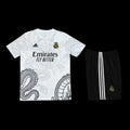 Ensemble Réal Madrid Le 12 -ème Maillot, maillot de football blanc avec logo et détails bleus et roses, devant un fond neutre.