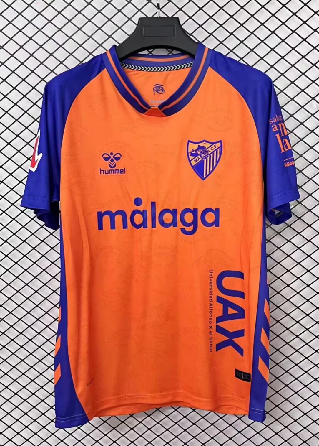 Maillot extérieur pour enfants 25/26 Malaga, marque Le 12 -ème Maillot, en tissu léger avec logo et détails de l'équipe.