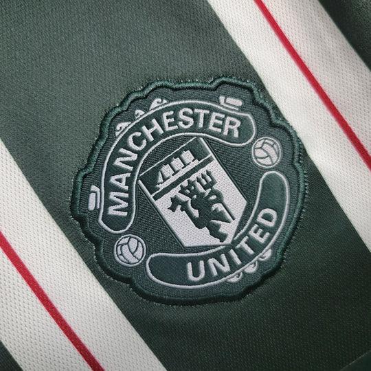 Maillot extérieur Manchester United 2023 2024 à manches longues, en tissu officiel Le 12 -ème Maillot, vue frontale.
