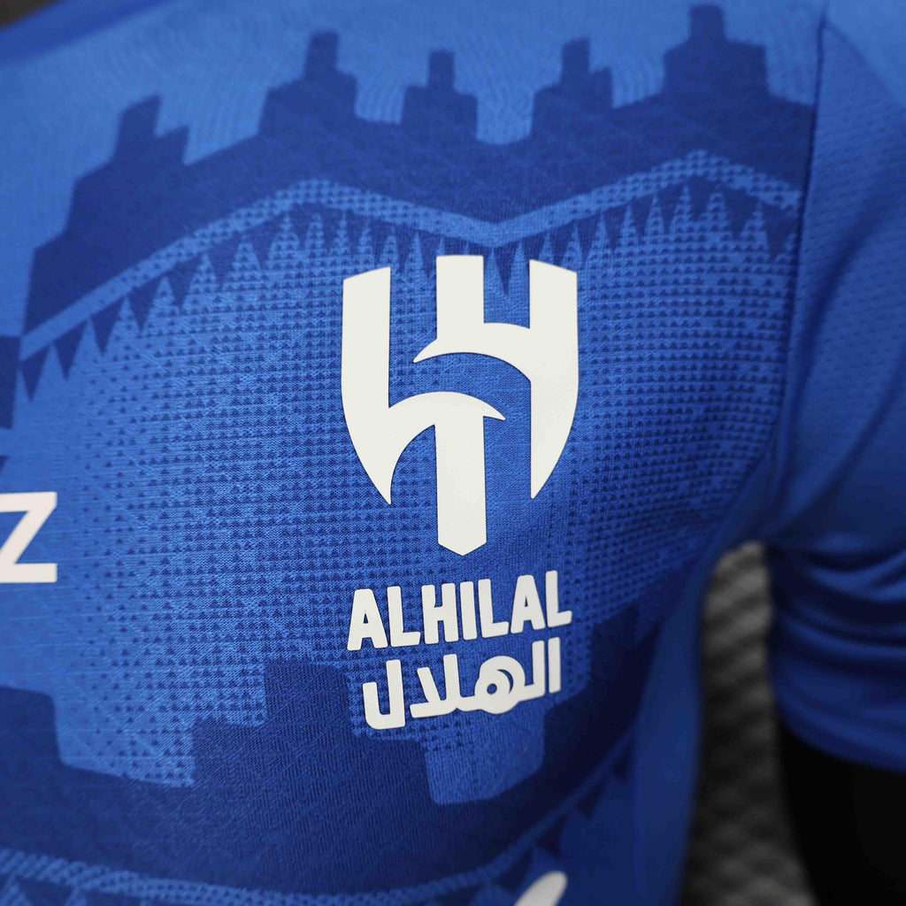 Maillot de football Al Hilal 2025-26, signé Le 12 -ème Maillot, en tissu bleu avec logo et motifs sportifs visibles.