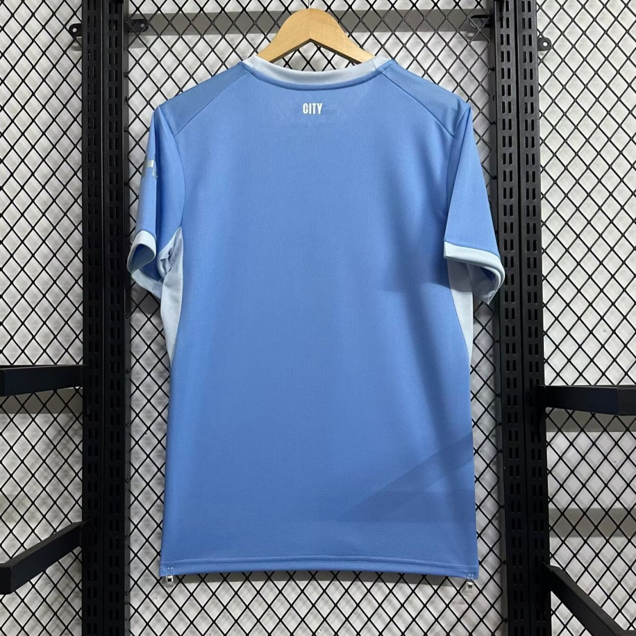 Maillot domicile Manchester City 26/27, marque Le 12 -ème Maillot, vue du maillot bleu avec logo et détails.