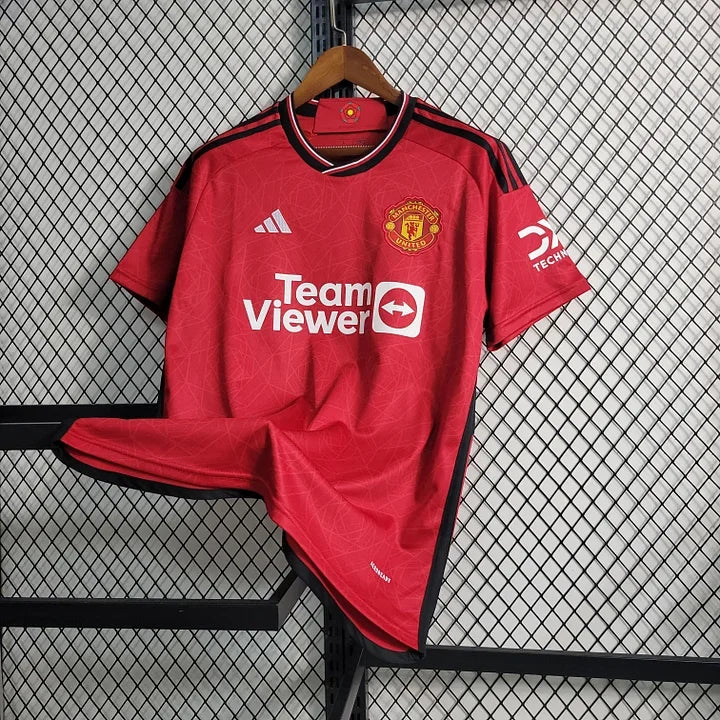 Maillot domicile Manchester United 2023-2024, marque Le 12 -ème Maillot, avec logo et design officiel visible sur le vêtement.
