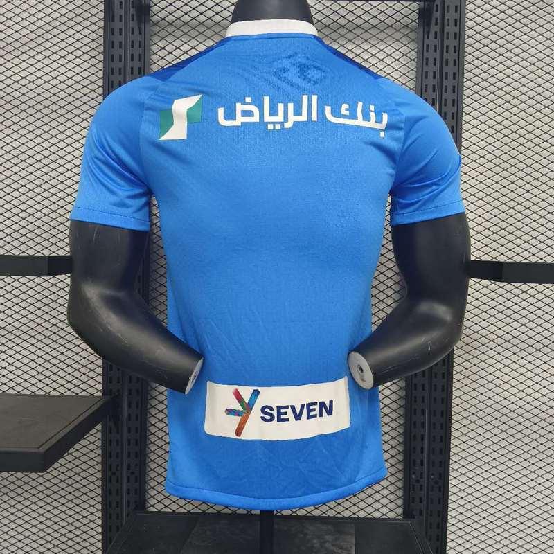 Maillot de football AL-Hilal 2023-24, maillot officiel de l'équipe, en tissu bleu avec logo et détails sportifs.