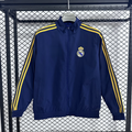 Veste coupe-vent réversible Real Madrid Le 12 -ème Maillot, couleur noire et blanche, avec logo du club visible.