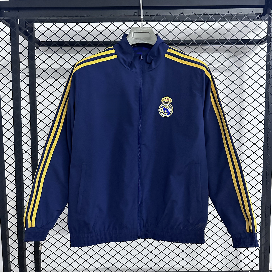 Veste coupe-vent réversible Real Madrid Le 12 -ème Maillot, couleur noire et blanche, avec logo du club visible.