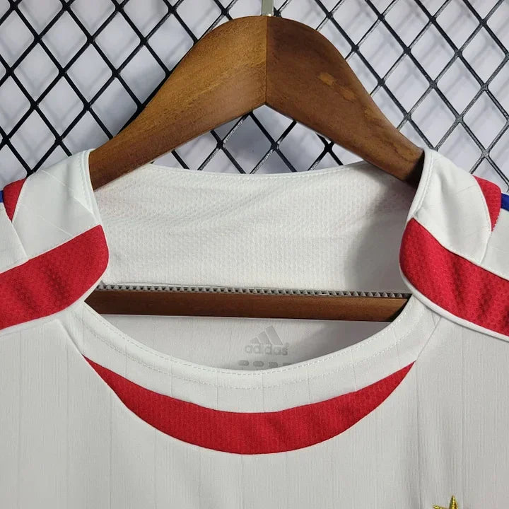 Maillot rétro de l'équipe de France 2006, marque Le 12 -ème Maillot, avec logo et design vintage visible sur le maillot.