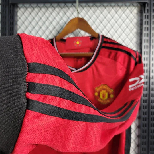 Maillot Manchester United 2023 2024 à manches longues, bleu et blanc, avec logo du club et détails de design.
