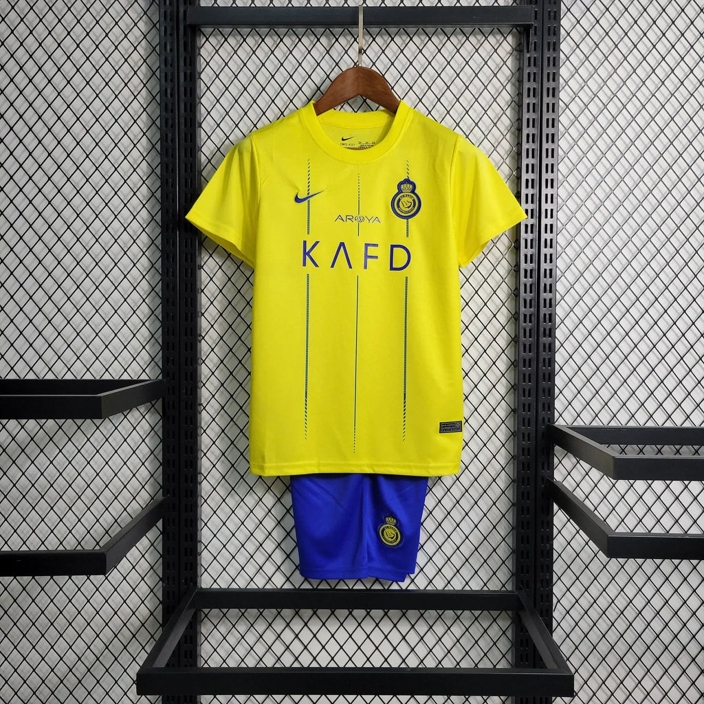 Kit enfant Al Nassr de Le 12, maillot junior avec logo et design officiel, veste et short assortis pour jeunes supporters.