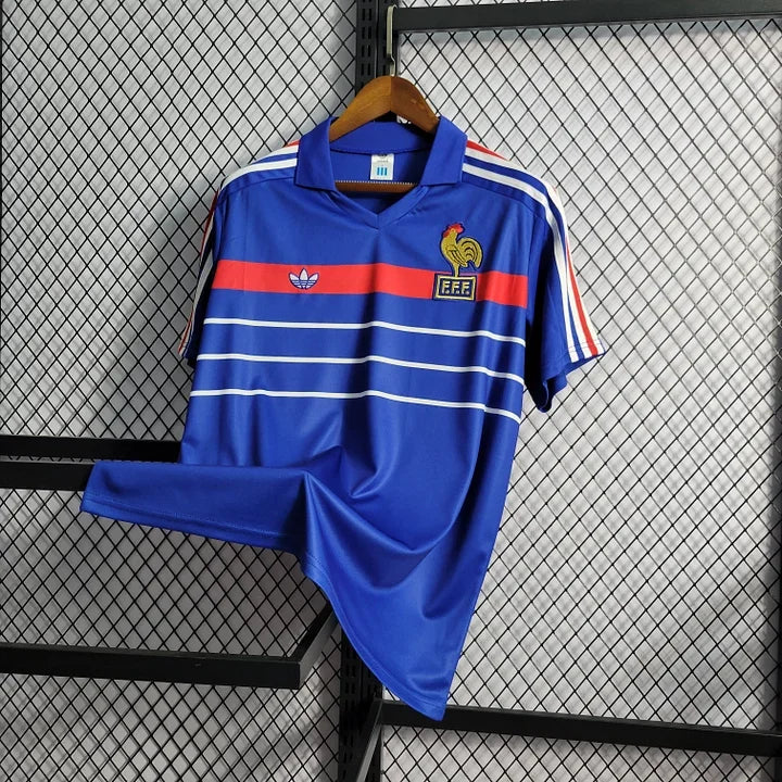 Maillot rétro de l'équipe de France 1985/86 Le 12, maillot de football bleu avec logo et détails vintage visible.
