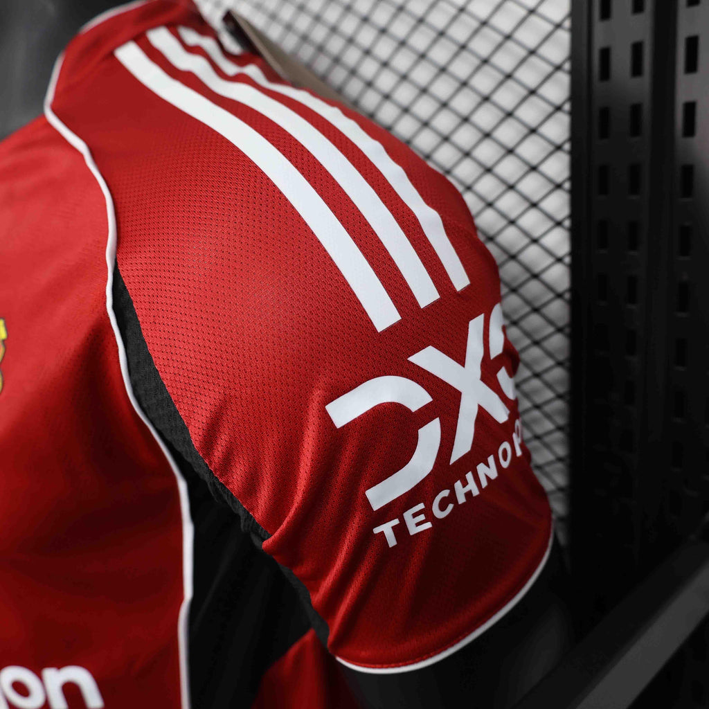 Maillot Manchester United 2025-26 Le 12 -ème Maillot, maillot de football rouge avec logo et détails de l'équipe.