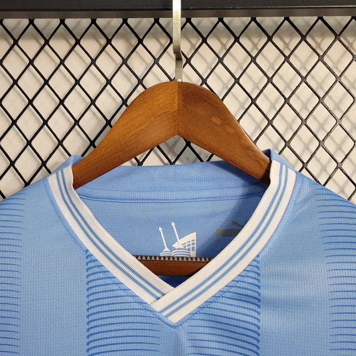 Maillot domicile Manchester City saison 2023-2024 Le 12 -ème Maillot, maillot de football bleu avec logo et détails blancs.