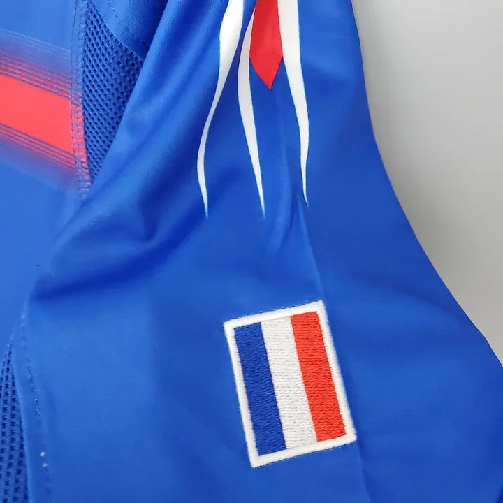 Maillot de l'équipe de France 2004 Le 12, maillot de football bleu avec logo officiel, vue de face.