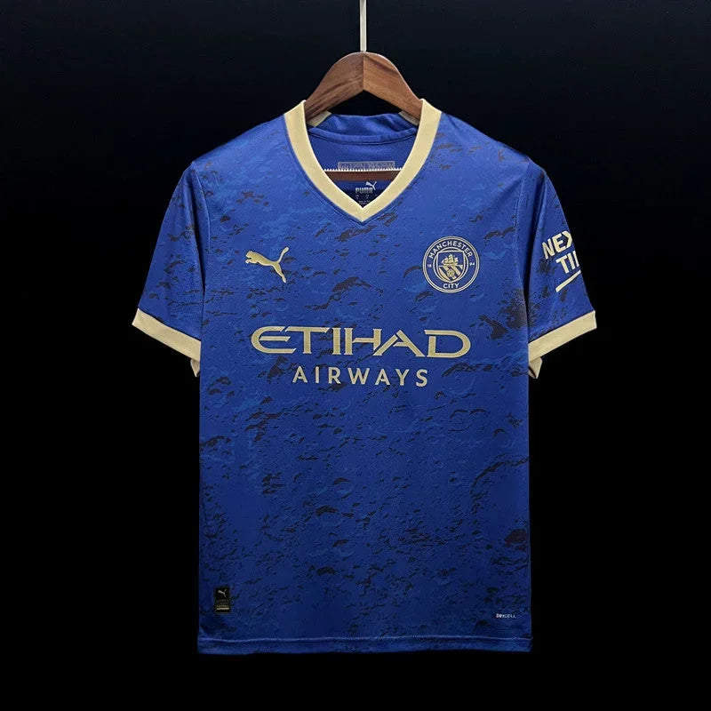 Maillot Manchester City 2023/24 Le 12 -ème Maillot, devant avec logo et détails en bleu et blanc.