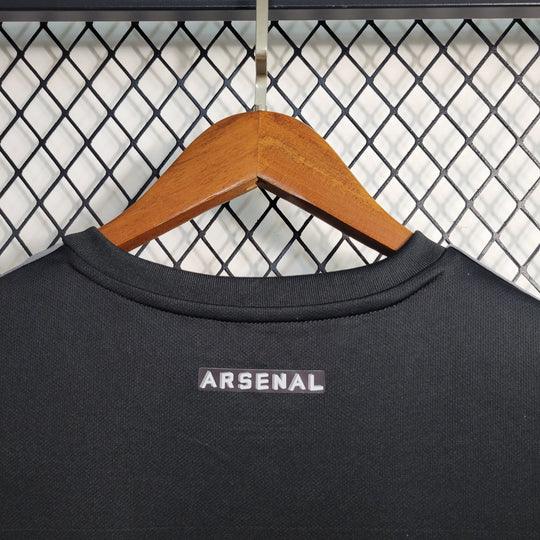 Maillot de football noir Arsenal 2023-2024 Le 12 -ème Maillot avec logo et détails du club, porté sur un mannequin.