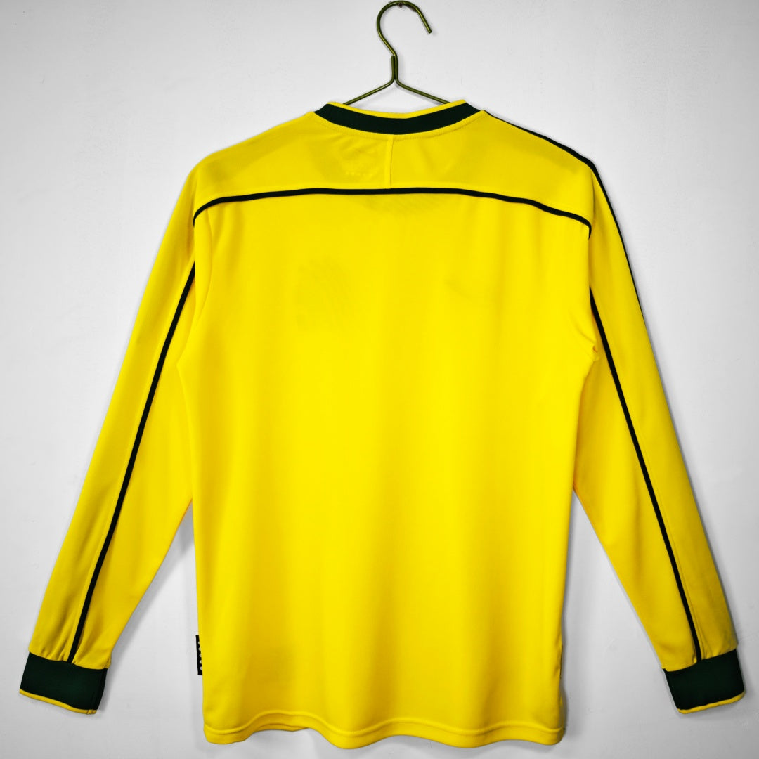Maillot domicile rétro Brésil 1998 à manches longues, marque Le 12 -ème Maillot, détail du design sur le tissu blanc et vert.