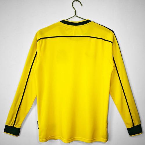 Maillot domicile rétro Brésil 1998 à manches longues, marque Le 12 -ème Maillot, détail du design sur le tissu blanc et vert.