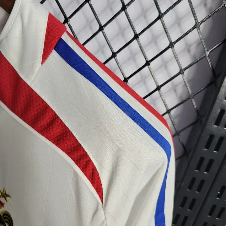Maillot rétro de l'équipe de France 2006 par Le 12 -ème Maillot, vue de face avec détails du design bleu et logo.