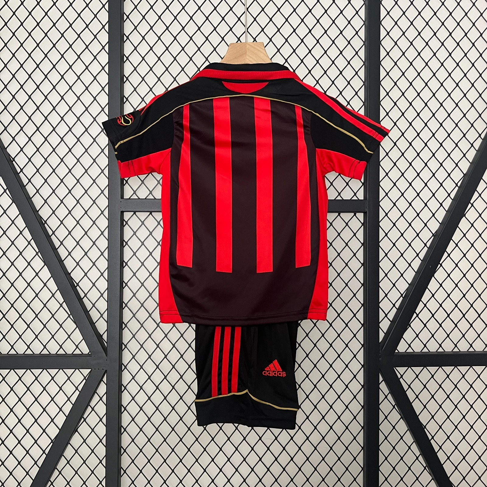 Ensemble enfant rétro AC Milan Le 12 -ème Maillot, maillot rouge et noir avec logo du club, vue de face.
