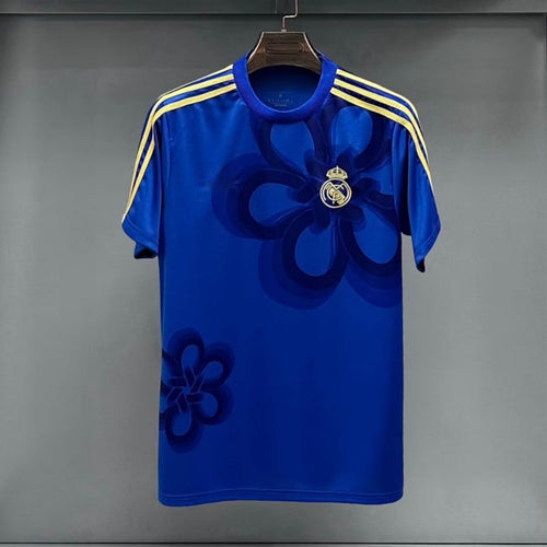 Maillot Real Madrid 25/26 bleu, marque Le 12 -ème Maillot, design spécial, vue de face avec logo et détails du maillot.